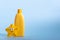 Yellow plastic bottle with baby cosmetic and funny bath toy. The concept of kid's skin care.