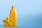 Yellow plastic bottle with baby cosmetic and funny bath toy. Soap bubbles on a background. The concept of children's