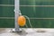 Yellow plastic buoy attached to a metal fence on the bank of a lake with green water