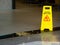 Yellow plastic cone with sign showing warning of wet floor in restaurant in department store