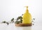 Yellow plastic container with a dispenser on a wooden background and a branch of eucalyptus on a white background. Container for