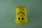 A yellow plastic cup with a smiling face, so it is very popular with children. Blue Background. Kids toys, kid friendly