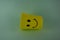 A yellow plastic cup with a smiling face, so it is very popular with children. Blue Background. Kids toys, kid friendly