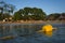 Yellow plastic float buoy on thick rope in calm water overlooking the tropical island Koh Tao, Sairee beach, Thailand