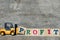 Yellow plastic forklift hold letter P to complete word profit on