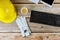 Yellow plastic safety helmet on construction builder office and leather work gloves computer keyboard