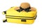 Yellow plastic suitcase for travel and womens straw hat