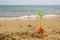 Yellow plastic toy shovel on sand beach at the seaside. Free space for text. Vacation, holiday concept