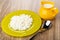 Yellow plate with defatted cottage cheese, jug with yogurt, spoon on table