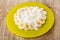 Yellow plate with grainy cottage cheese, slices of banana and yogurt on table