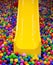 Yellow playground slide and plastic balls