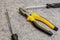 Yellow pliers surrounded by screwdrivers close-up of focus in the center of the frame working tool work assembly