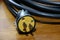 Yellow plug with black cable on the wooden floor.