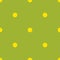 Yellow polka dots seamless pattern on green.