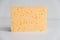 Yellow porous sponge on a white background. Copy, empty space for text