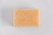 Yellow porous sponge on a white background. Top view. Copy, empty space for text