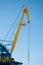 Yellow port crane on blue sky background