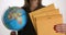 Yellow postal envelope with a globe in female hand