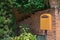 Yellow postbox in front of the house entrance