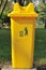 Yellow public bin in garden.