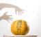 Yellow pumpkin no table with hands shadow on wall