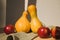 Yellow pumpkins on a light background with red apples on green towel. Autumn composition. Halloween background