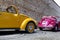 Yellow and purple colored classic convertible cars side view