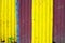 Yellow and purple metallic fence closeup, colorful material photo texture. Corrugated iron rustic surface closeup