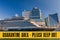 Yellow quarantine sign over a cruise ship at port