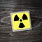 A yellow radiation warning symbol, sign or icon on a wooden background