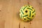 Yellow rattan ball with green stripes