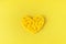 Yellow rattan wicker heart on a yellow background.Symbol of love.Valentine`s Day