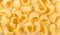 Yellow raw pasta background, fresh italian traditional macaroni,