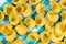 Yellow raw pasta background, italian traditional macaroni on blue checkered fabric,