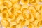 Yellow raw pasta background, raw italian traditional macaroni,