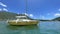 Yellow recreational sailing boat on ocean with mountain, blue sky and clouds in Hong Kong