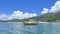 Yellow recreational sailing boat on ocean with mountain, blue sky and clouds in Hong Kong