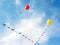 Yellow and red balloons flying in blue sky