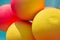 Yellow and red balls balloons on cloud sky background. Macro close up image. Vivid holiday poster with copy space. Sunny happy day