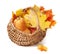 Yellow, red Canadian maple leaves and pumpkin in a wicker basket on a white background. Autumn concept. Harvesting. Isolated