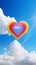A yellow and red heart against a sky of clouds. Heart as a symbol of affection and