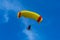 Yellow and red powered tandem para glider flying