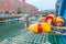 Yellow and red striped buoys or floats on crab pots against background of fishing port and industrial buildings