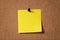 Yellow reminder sticky note on cork board