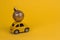 yellow retro car carries a golden christmas ball on a yellow copy space background