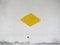 Yellow rhombus or diamond shape painted on a white wall