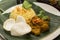 Yellow Rice with Rendang Beef and Shrimp Crackers, served on a banana leaf