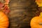 Yellow ripe pumpkin, maple leaves on wooden background.