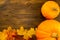 Yellow ripe pumpkin, maple leaves on wooden background. Thanksgiving