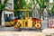 Yellow roller for tamping asphalt at the site of road construction works on a city street on a summer day. Road-building machinery